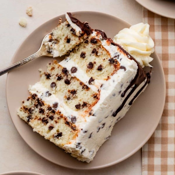 slice of chocolate chip 3 layer cake with chocolate ganache drip.