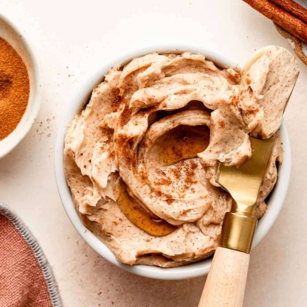 cinnamon butter in white dish with gold butter knife.