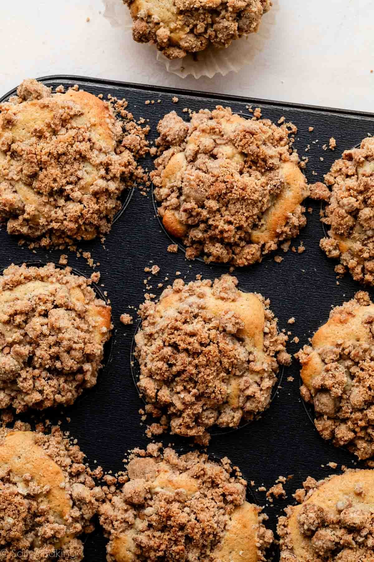 muffin pan with crumb cake muffins in it.