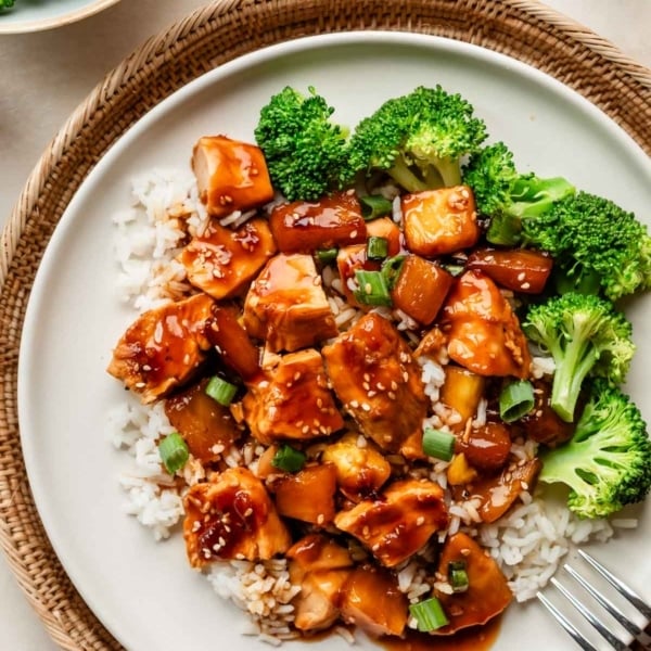 baked pineapple chicken teriyaki on white plate with broccoli and white rice.
